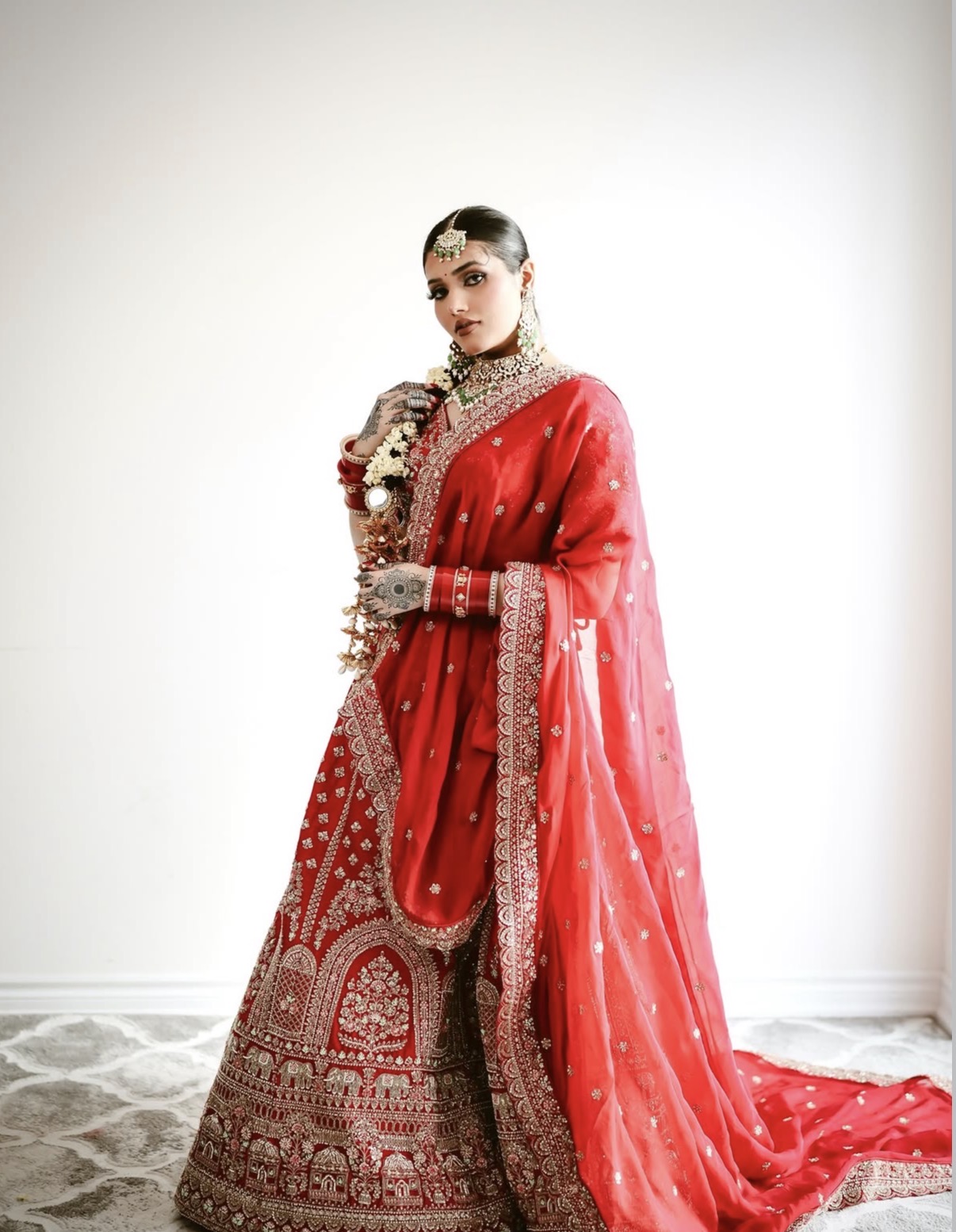 Bride in a red lehenga and dupatta with kundan jewellery