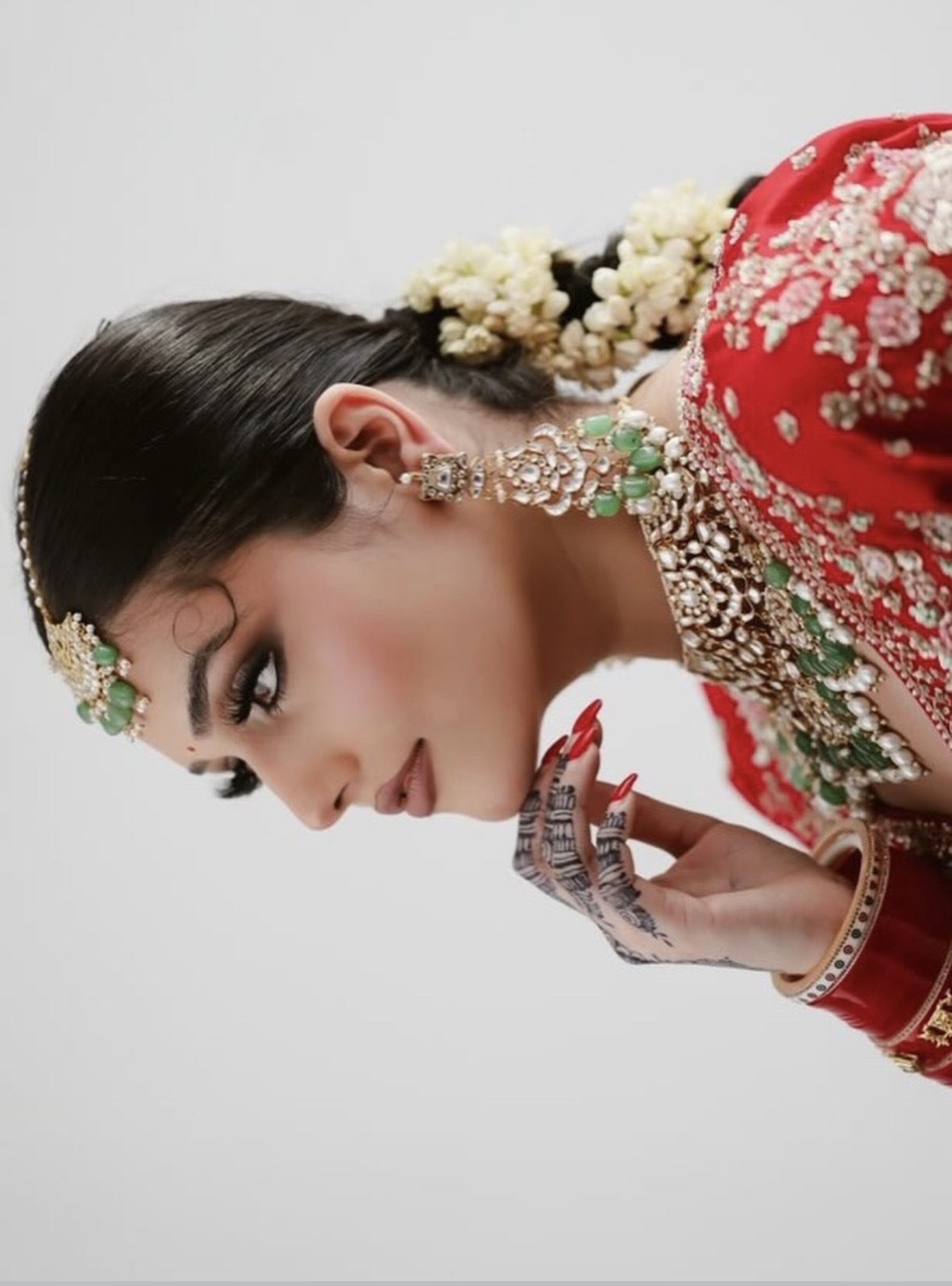 Close-up of red bridal makeup with kundan jewellery by Tannu Bedi Artistry